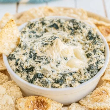 Creamy slow cooker spinach artichoke dip served in a bowl with chips