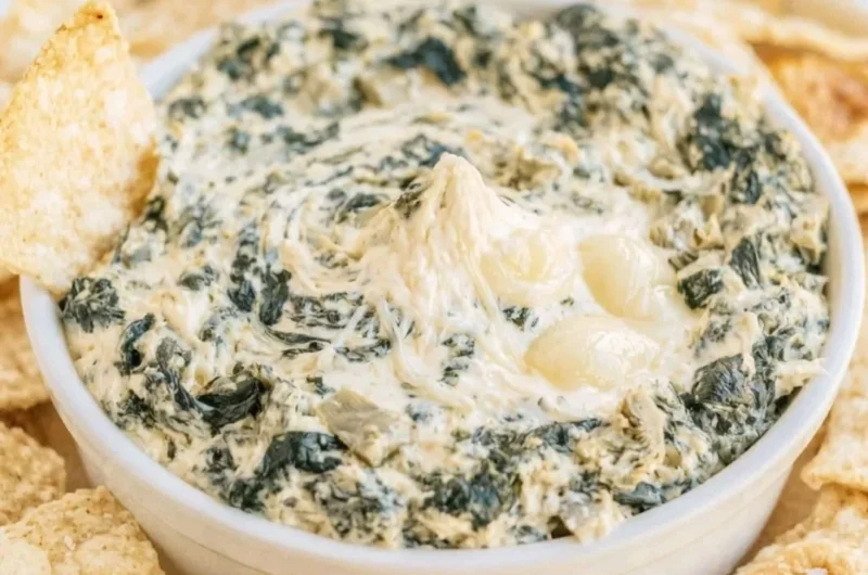 Creamy slow cooker spinach artichoke dip served in a bowl with chips
