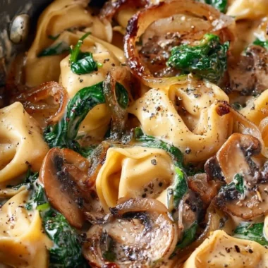 Creamy tortellini dish with spinach, mushrooms, and caramelized onions