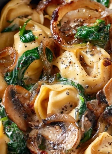 Creamy tortellini dish with spinach, mushrooms, and caramelized onions