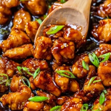 Plate of honey garlic chicken garnished with green onions