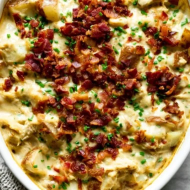 Savory Creamy Chicken Potato Casserole topped with cheese and herbs