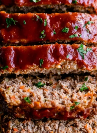 Delicious Whole30 Meatloaf served on a plate with fresh herbs.