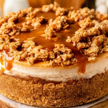 Slice of cozy apple crumble cheesecake topped with cinnamon and apples