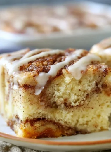 Delicious cozy cinnamon roll cake topped with icing on a rustic table