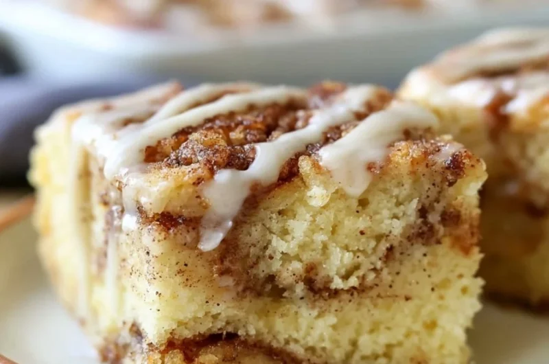 Delicious cozy cinnamon roll cake topped with icing on a rustic table