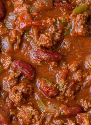 Bowl of cozy easy chili recipe topped with cheese and herbs