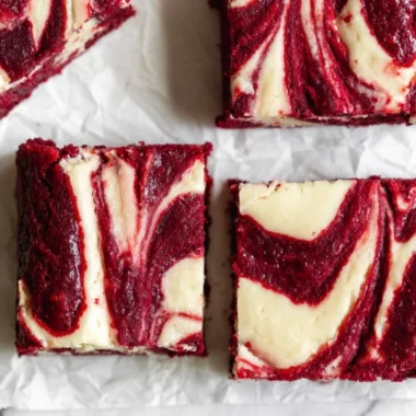 Delicious red velvet cheesecake brownies with cream cheese layer and red velvet swirl.