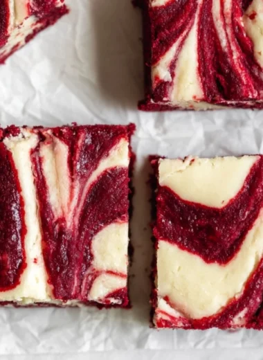 Delicious red velvet cheesecake brownies with cream cheese layer and red velvet swirl.