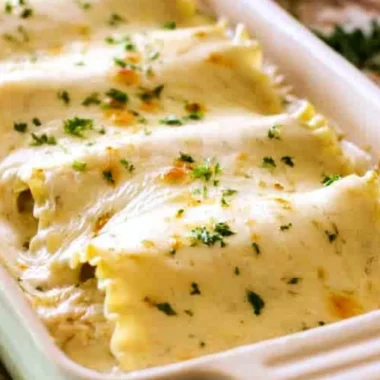 Creamy Chicken Alfredo Roll Ups served on a plate, topped with parsley.