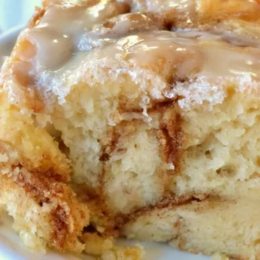 Delicious homemade cinnamon roll cake topped with icing and cinnamon sugar