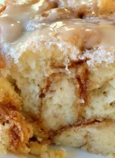 Delicious homemade cinnamon roll cake topped with icing and cinnamon sugar