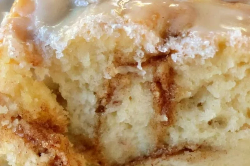 Delicious homemade cinnamon roll cake topped with icing and cinnamon sugar