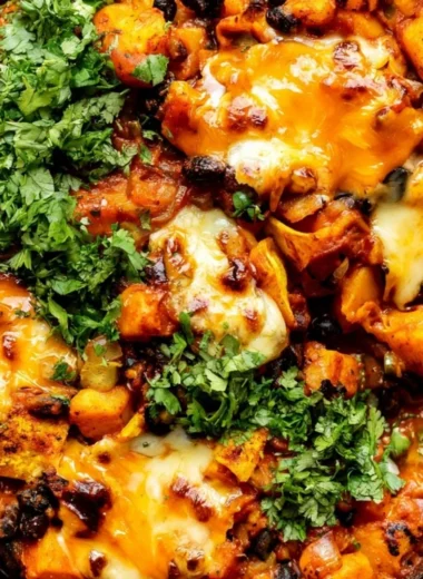 Cozy butternut squash and black bean enchiladas cooked in a skillet