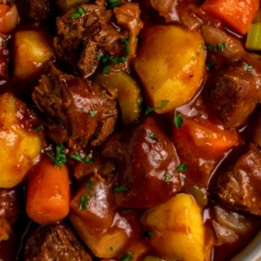 Delicious crock pot beef stew served in a hearty bowl with fresh herbs.