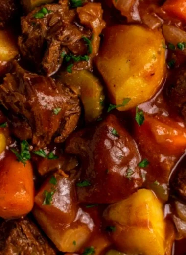 Delicious crock pot beef stew served in a hearty bowl with fresh herbs.