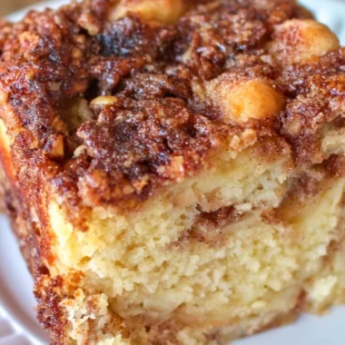 Delicious apple sour cream cake served on a wooden table with a cozy ambiance