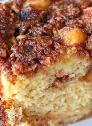 Delicious apple sour cream cake served on a wooden table with a cozy ambiance