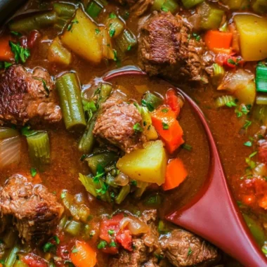 Delicious cozy vegetable beef soup in a bowl with fresh ingredients