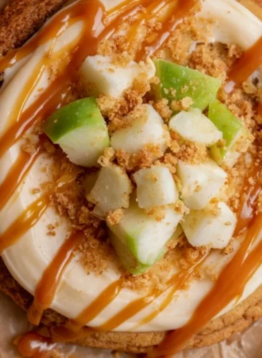 Delicious Crumbl caramel apple cookies topped with caramel and apple pieces
