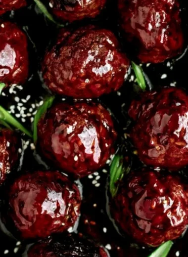 Plate of sticky Mongolian beef meatballs served with green onions and sauce