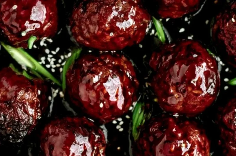Plate of sticky Mongolian beef meatballs served with green onions and sauce