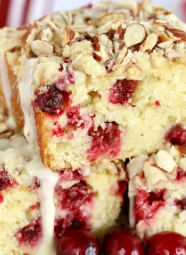 Homemade Cranberry Almond Cake decorated with fresh cranberries and almonds.