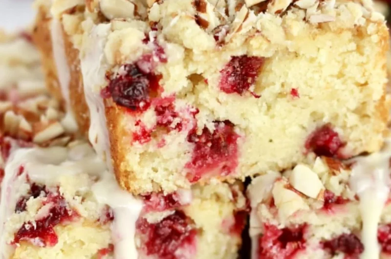 Homemade Cranberry Almond Cake decorated with fresh cranberries and almonds.
