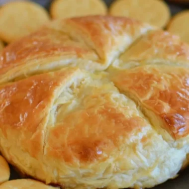 Delicious baked brie wrapped in flaky puff pastry, served as an elegant appetizer.