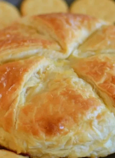 Delicious baked brie wrapped in flaky puff pastry, served as an elegant appetizer.