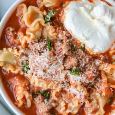 Bowl of healthy lasagna soup garnished with herbs and cheese