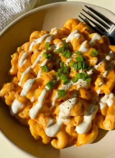 High protein buffalo chicken pasta topped with fresh herbs and cheese