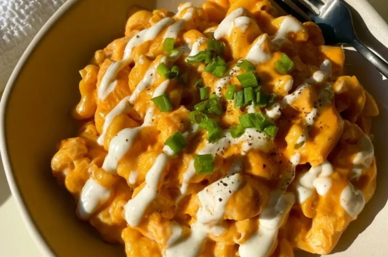 High protein buffalo chicken pasta topped with fresh herbs and cheese