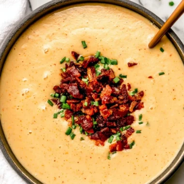 Bowl of high-protein cream of potato soup topped with herbs.