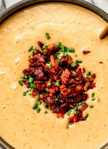 Bowl of high-protein cream of potato soup topped with herbs.