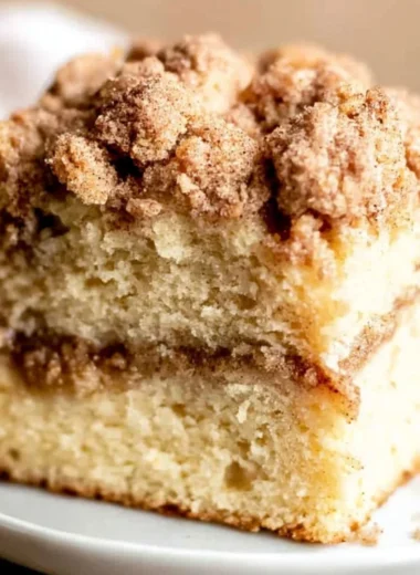 Sour cream coffee cake with cinnamon topping on a serving plate